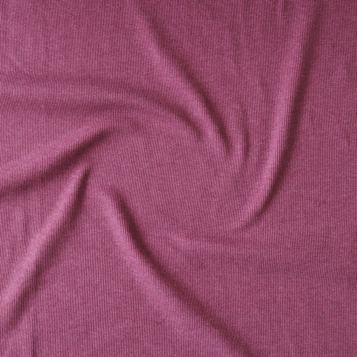 A close-up of draped ribbed knit fabric in a dusty magenta-purple color, showing the texture and folds.