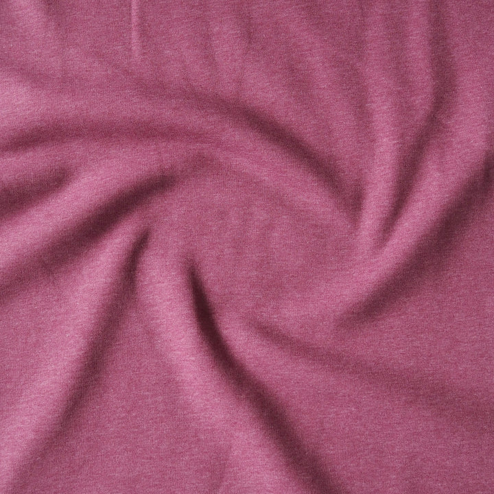 A close-up of heathered dusty rose pink fabric, swirled and draped to show its soft texture and drape.