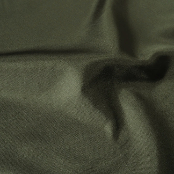 A close-up of draped olive green fabric with soft folds and a subtle sheen.