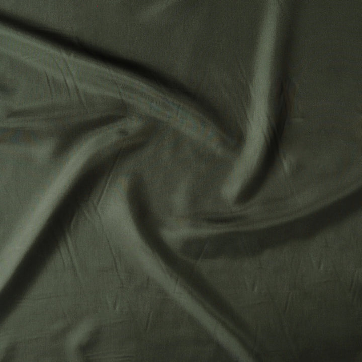 A close-up of draped olive green fabric with soft folds and a matte texture.