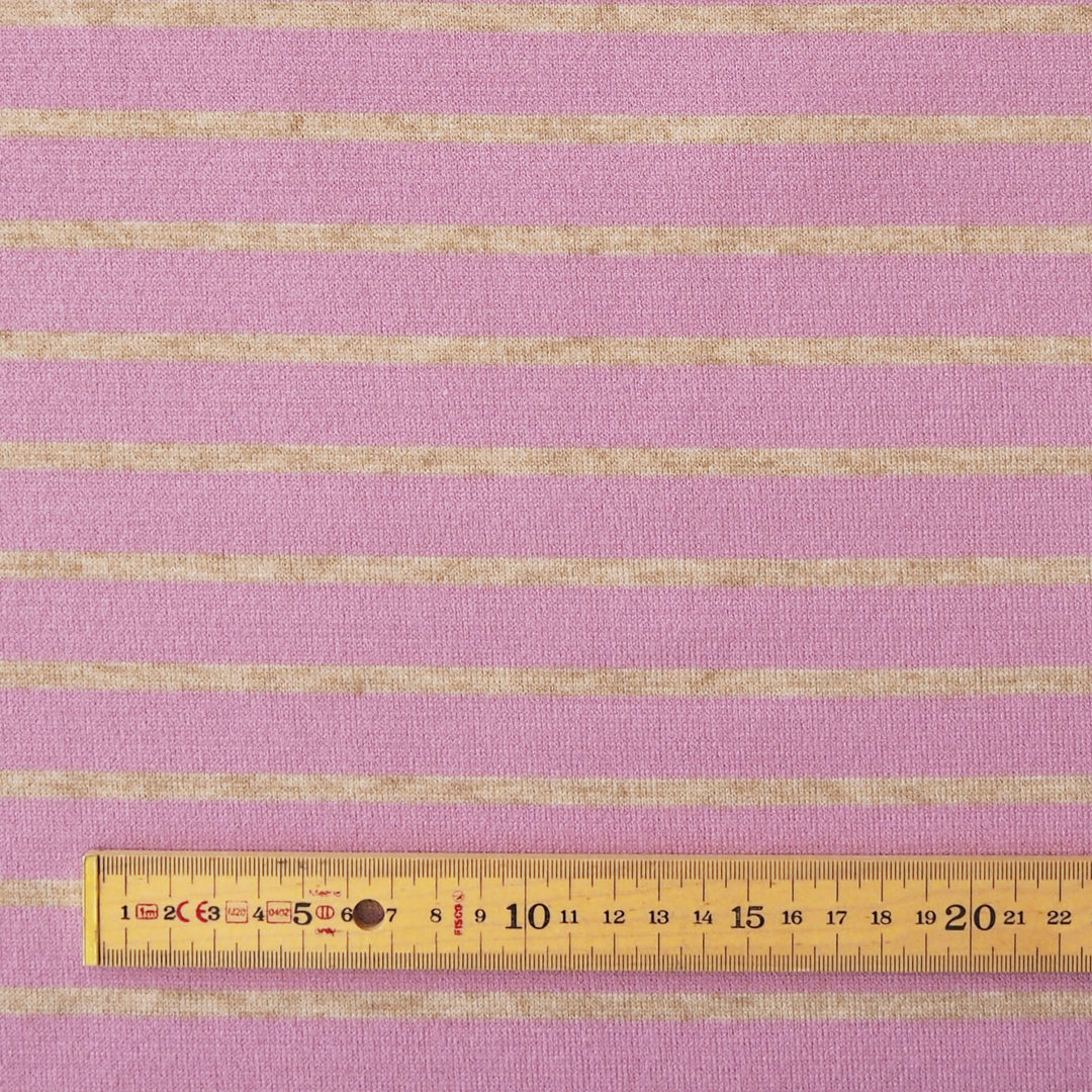 Pink and beige striped fabric shown flat with a wooden ruler at the bottom for scale.