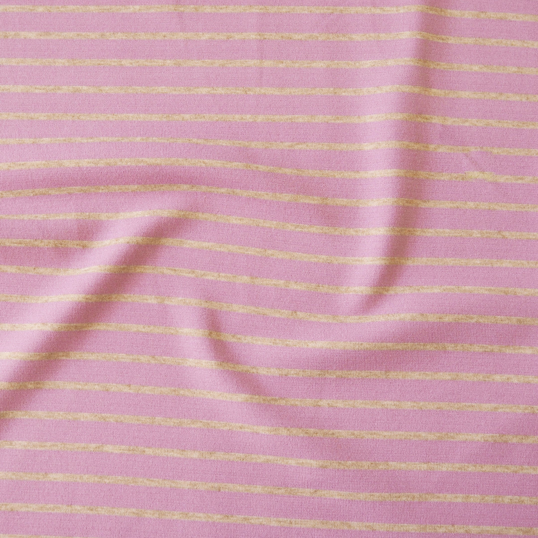 Pink fabric with thin horizontal yellow stripes, shown with soft folds and a textured weave.