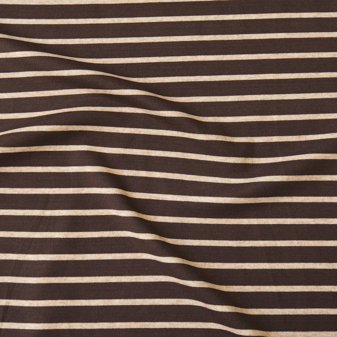A close-up of a striped fabric with alternating dark brown and light beige horizontal stripes, shown with soft folds.