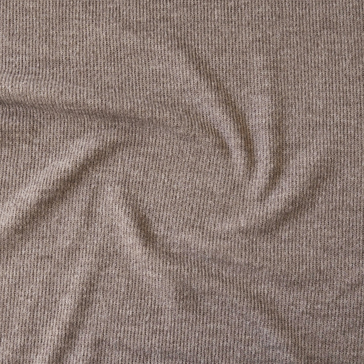 A close-up of a ribbed knit fabric in a warm taupe-brown color, showing the texture and drape of the material.