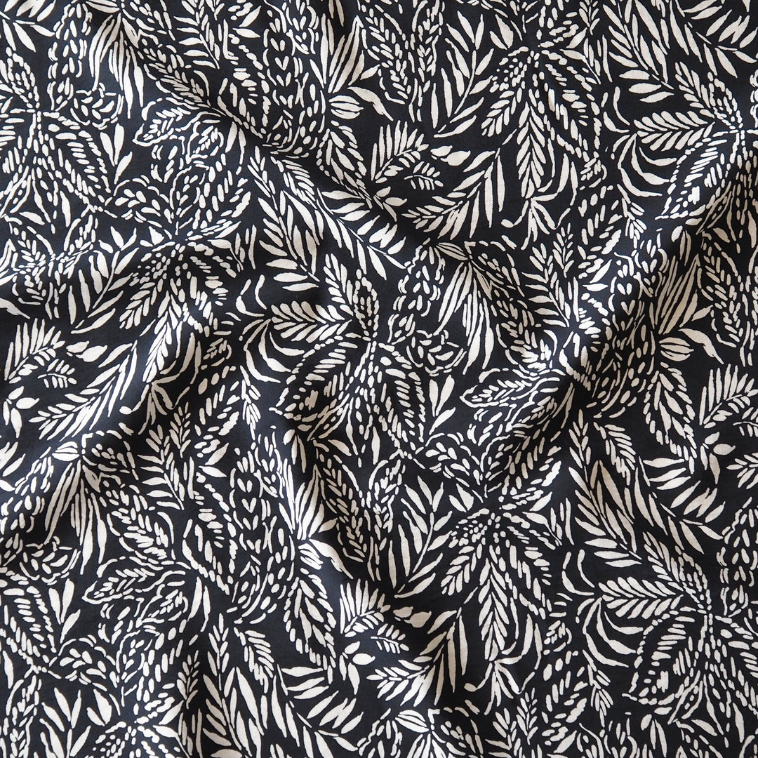 Deep navy and white tropical leaf patterned fabric with a textured, crinkled surface.
