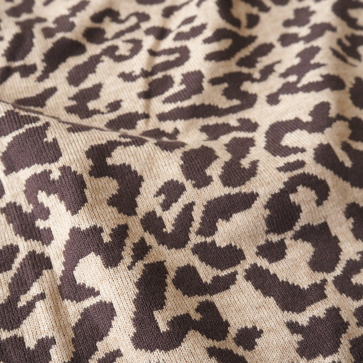 Close-up of a knitted fabric with a leopard print pattern in dark brown and beige.
