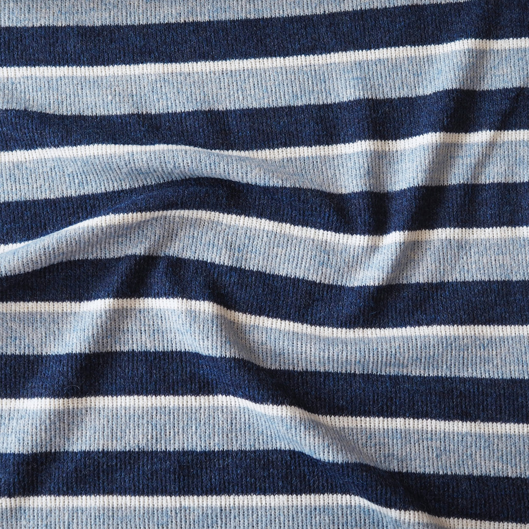 A close-up of a ribbed knit fabric with horizontal stripes in navy blue, light blue, and white.