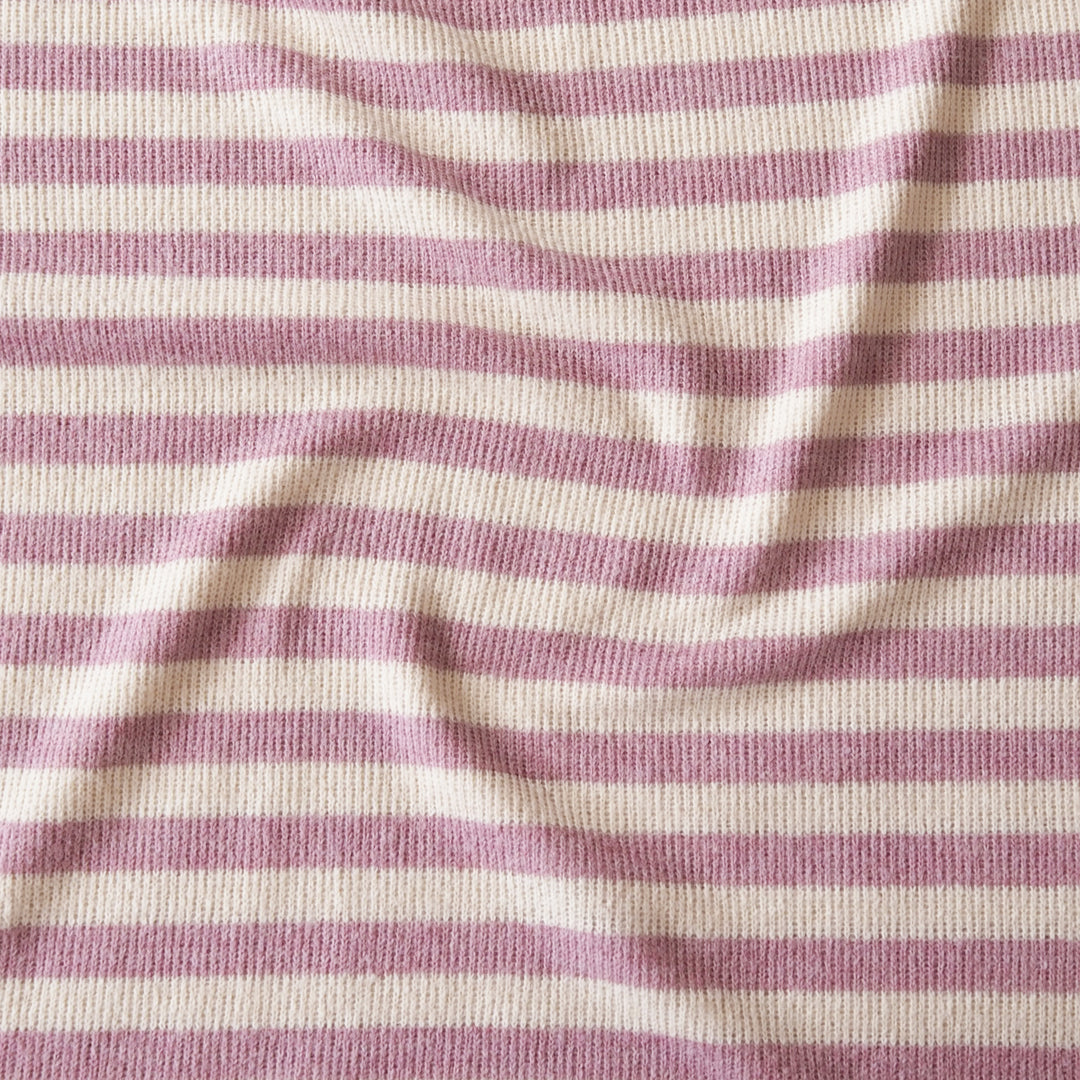 A close-up of a ribbed knit fabric with horizontal stripes in dusty mauve pink and cream.
