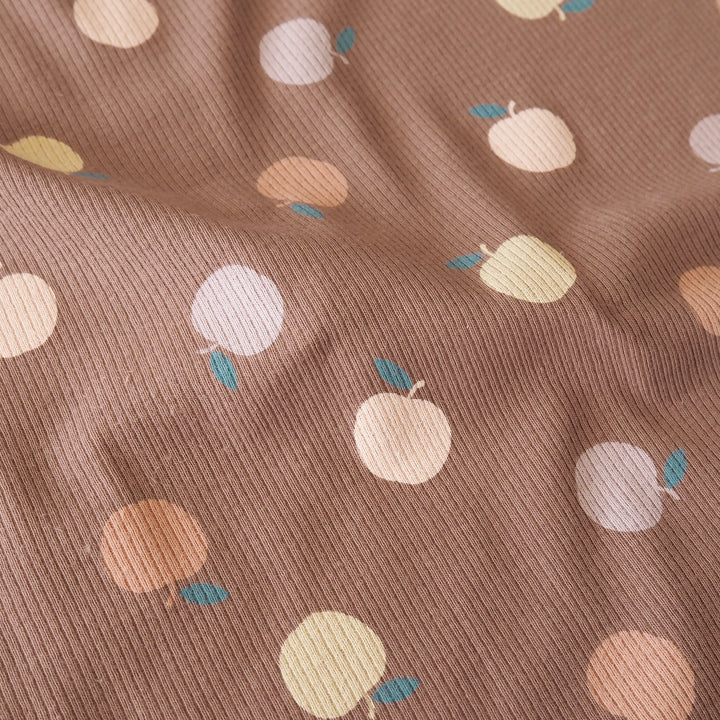 Brown ribbed fabric with a repeating pattern of stylized fruit in cream, peach, and pale yellow, each with a small blue leaf.