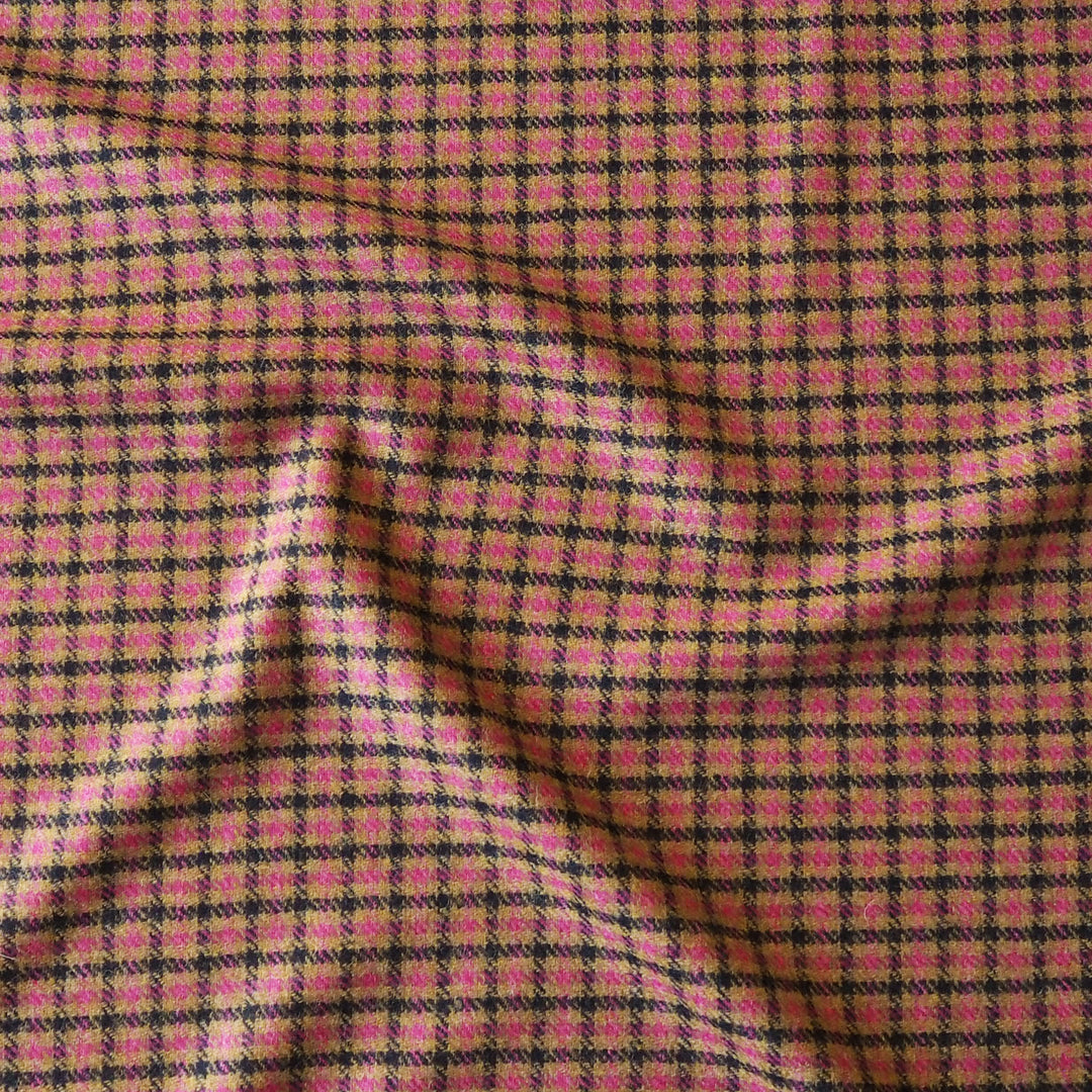A close-up of a pink and black checkered fabric with a textured, woven appearance and soft folds.