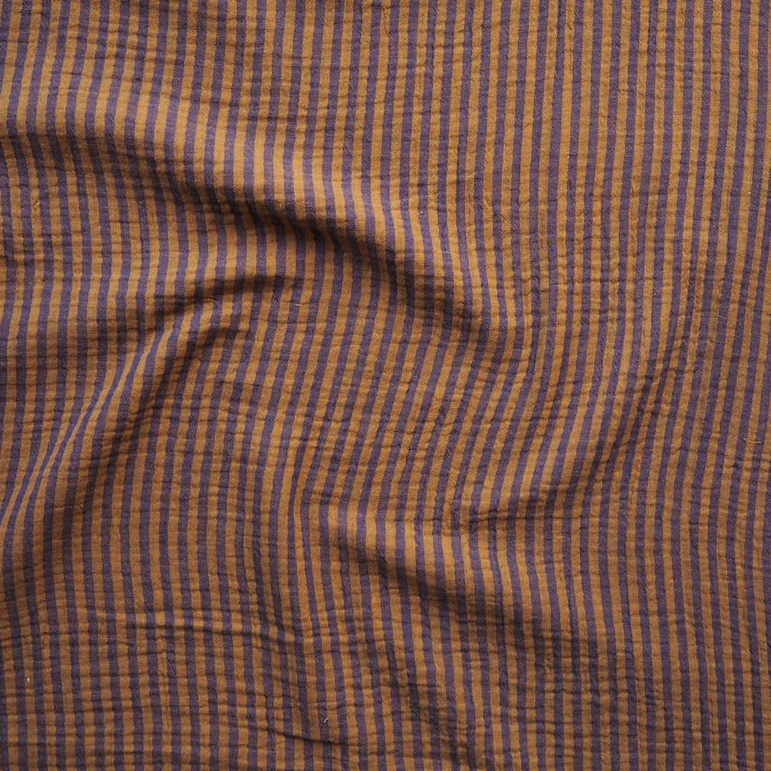 A close-up of a textured fabric with a fine vertical stripe pattern in brown and muted blue.