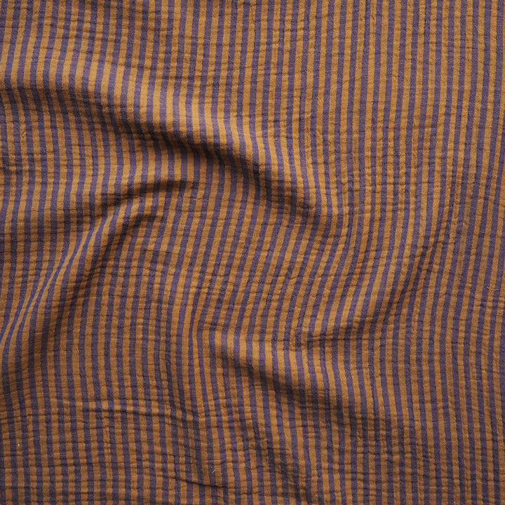 A close-up of a textured fabric with a fine vertical stripe pattern in brown and muted blue.
