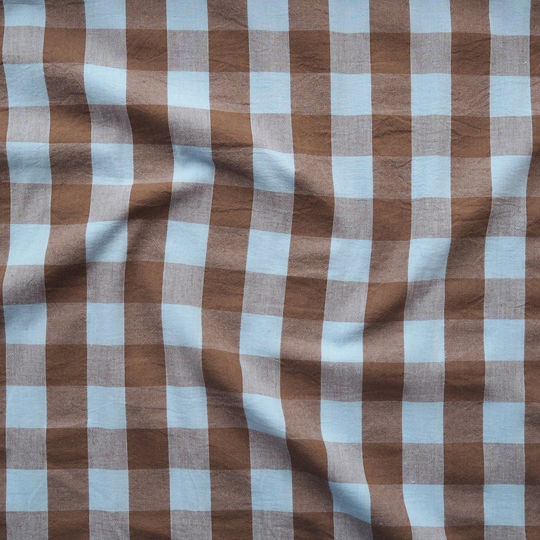 Brown and light blue gingham checkered fabric with a soft, draped texture.