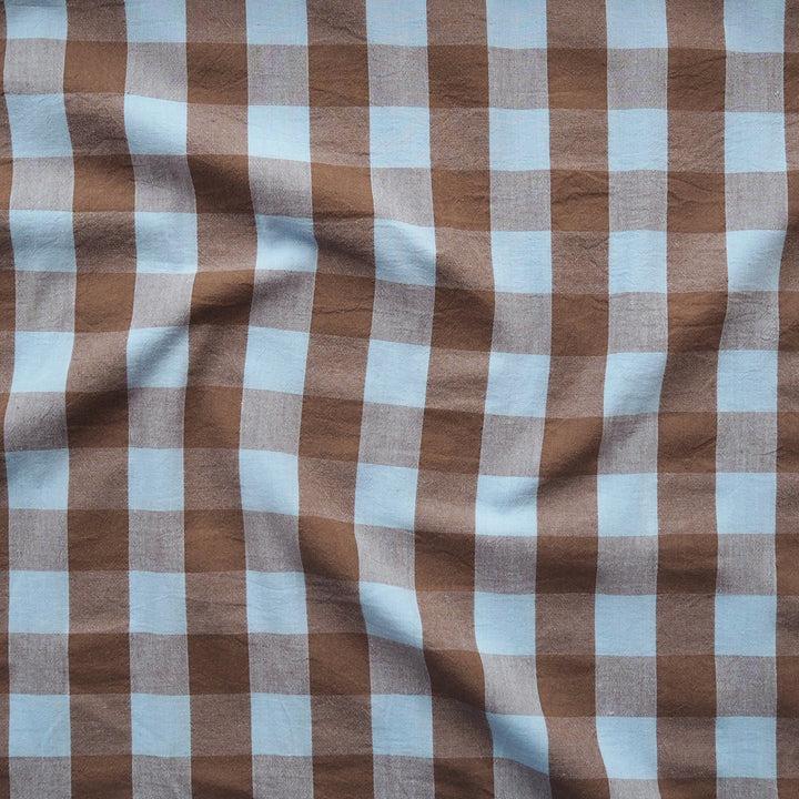 Brown and light blue gingham checkered fabric with a soft, draped texture.