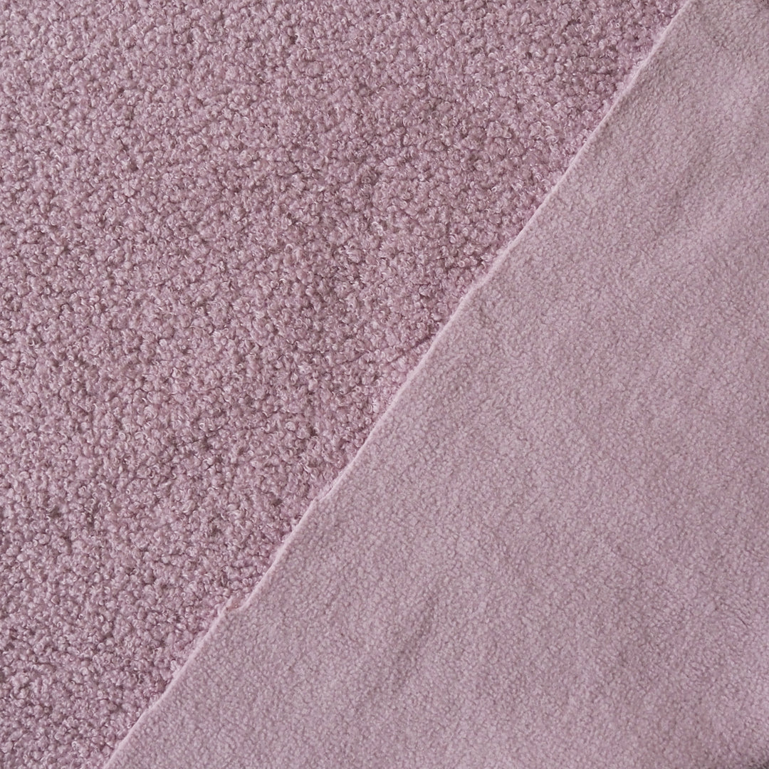 A close-up of dusty pink fabric showing two textures: a short-pile looped texture on the left and a smoother brushed texture on the right, divided diagonally.