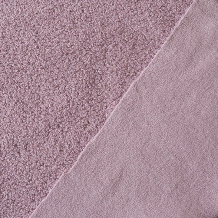 A close-up of dusty pink fabric showing two textures: a short-pile looped texture on the left and a smoother brushed texture on the right, divided diagonally.