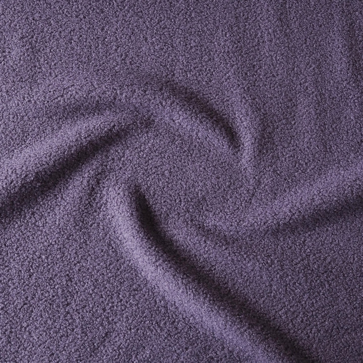 A close-up of textured purple fabric with a soft, plush surface and gentle swirls in the material.