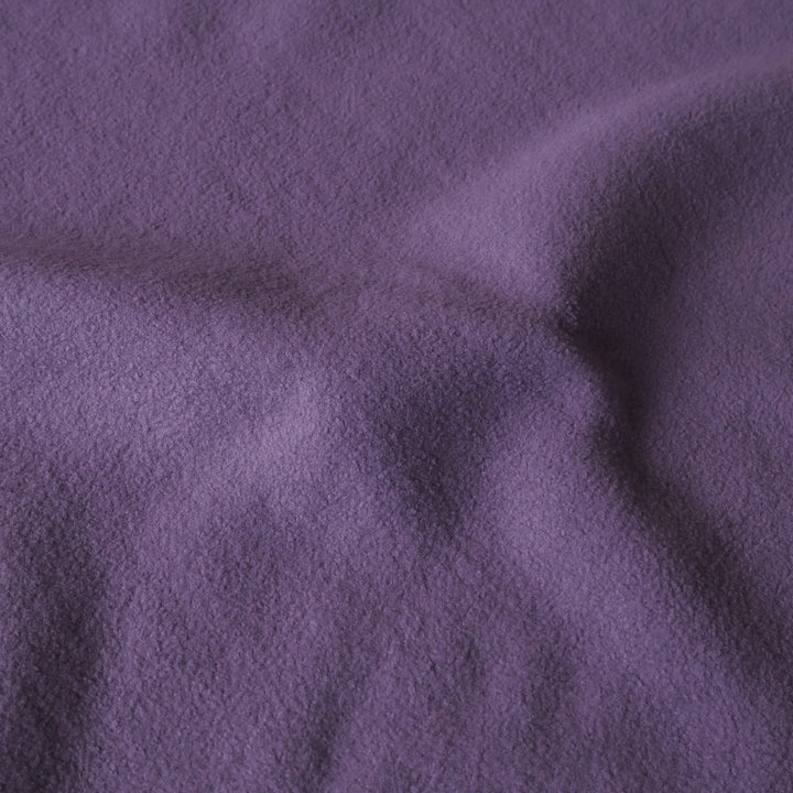 A close-up of draped purple fabric with a soft, textured surface.