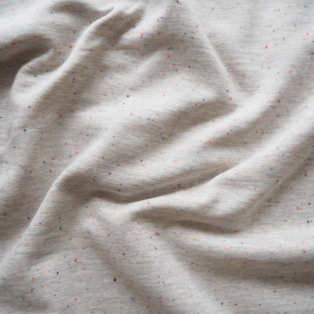 Light grey fleeceback sweatshirt fabric with colourful flecks.