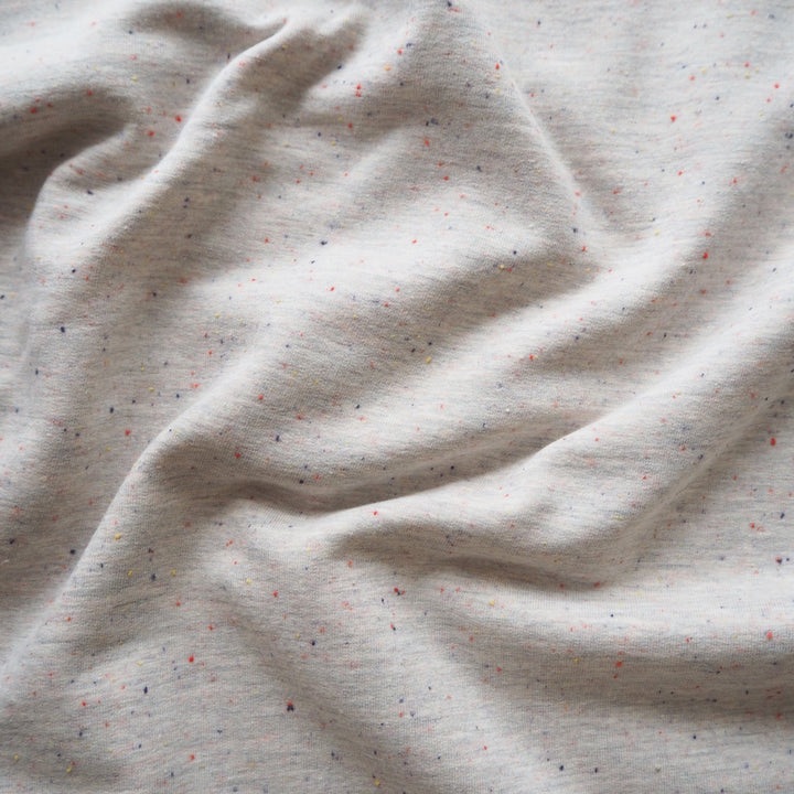 Light grey fleeceback sweatshirt fabric with colourful flecks.