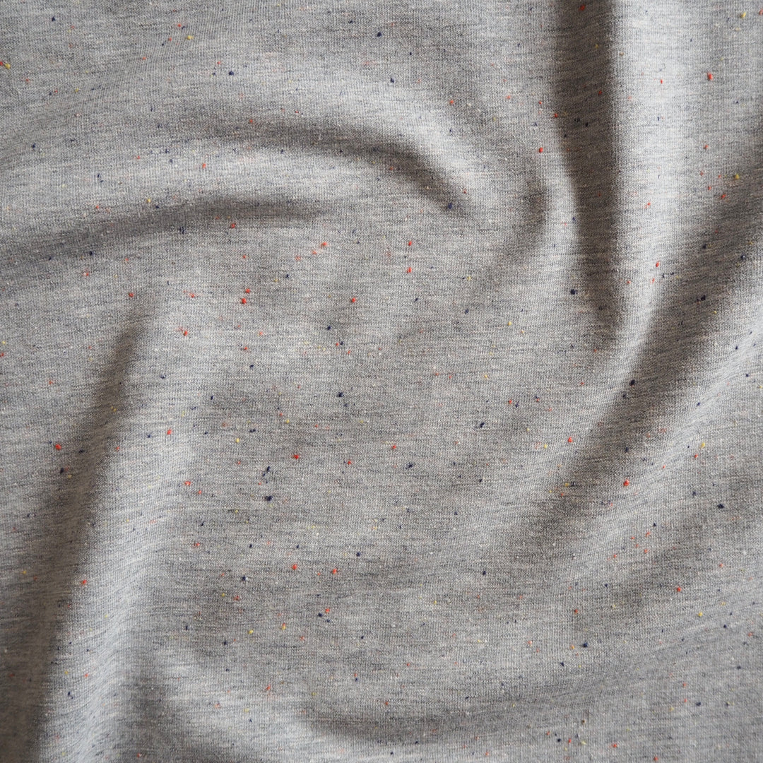 Silver grey fleeceback sweatshirt fabric with colourful flecks.