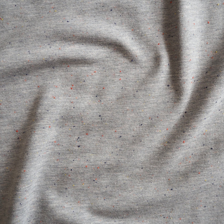 Silver grey fleeceback sweatshirt fabric with colourful flecks.