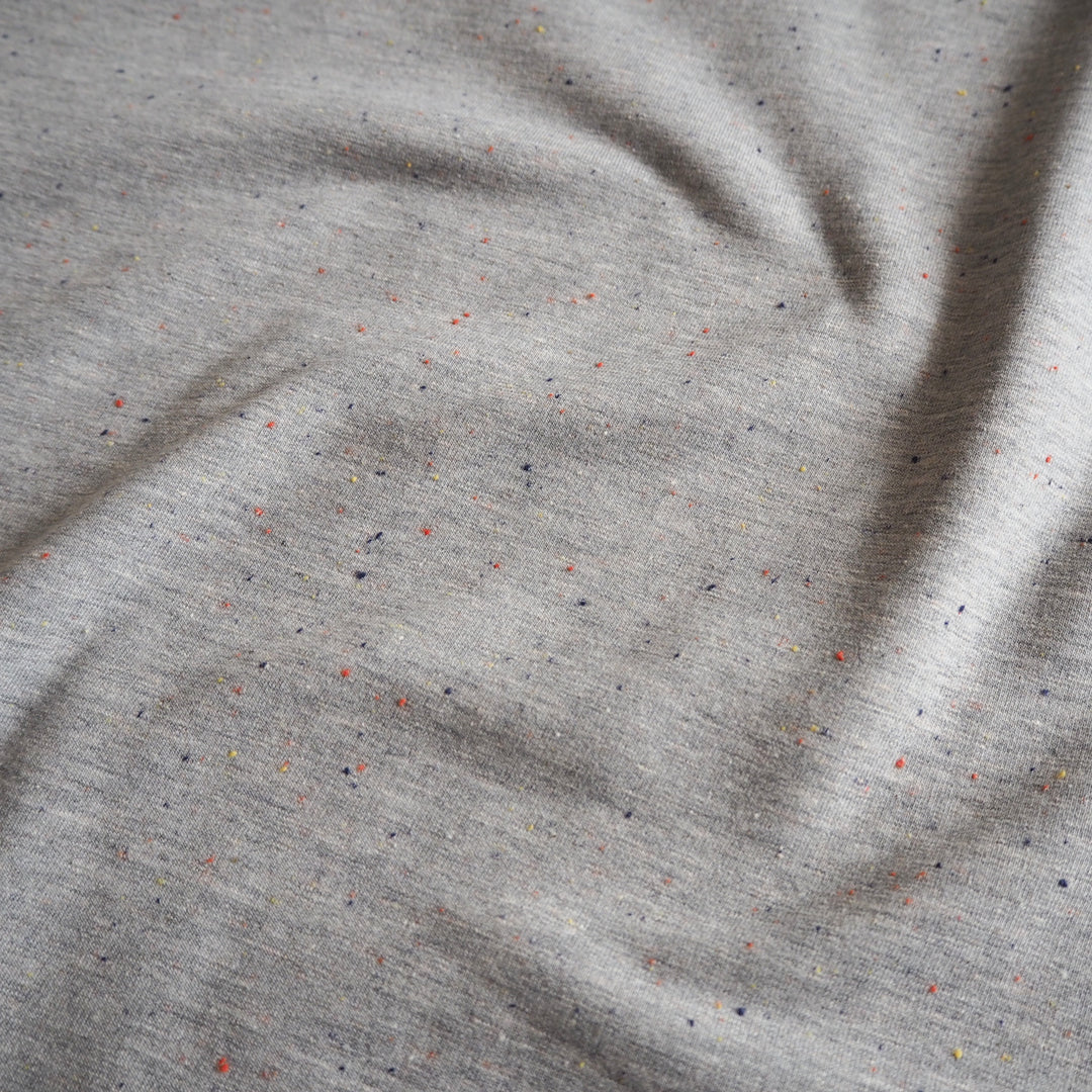 Silver grey fleeceback sweatshirt fabric with colourful flecks.