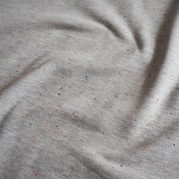 Silver grey fleeceback sweatshirt fabric with colourful flecks.