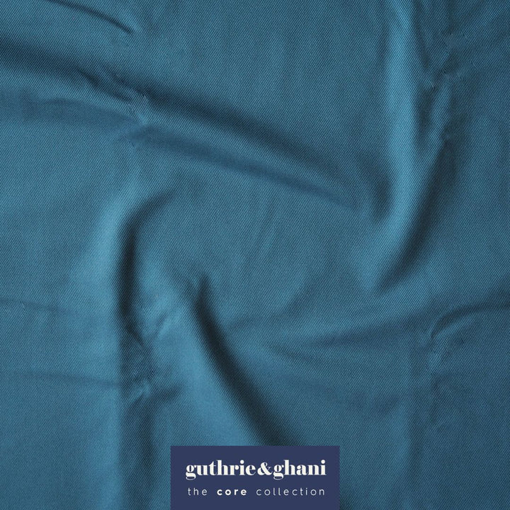 Close-up of teal fabric with 'guthrie & ghani' label in the corner