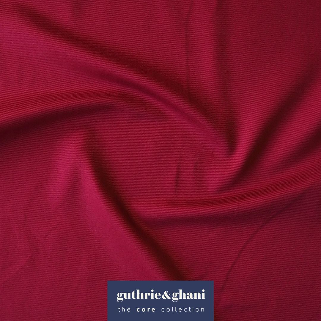 Close-up of red fabric with 'guthrie & ghani' logo in the corner