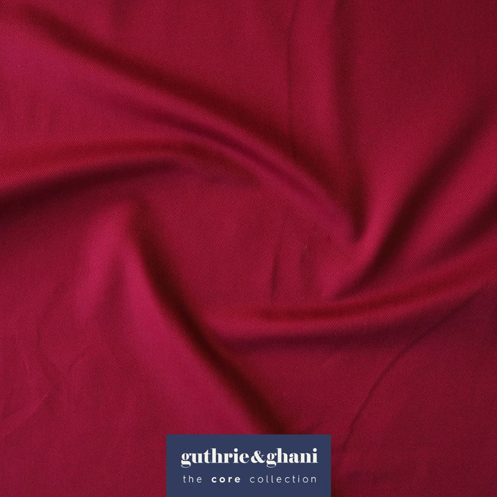 Close-up of red fabric with 'guthrie & ghani' logo in the corner
