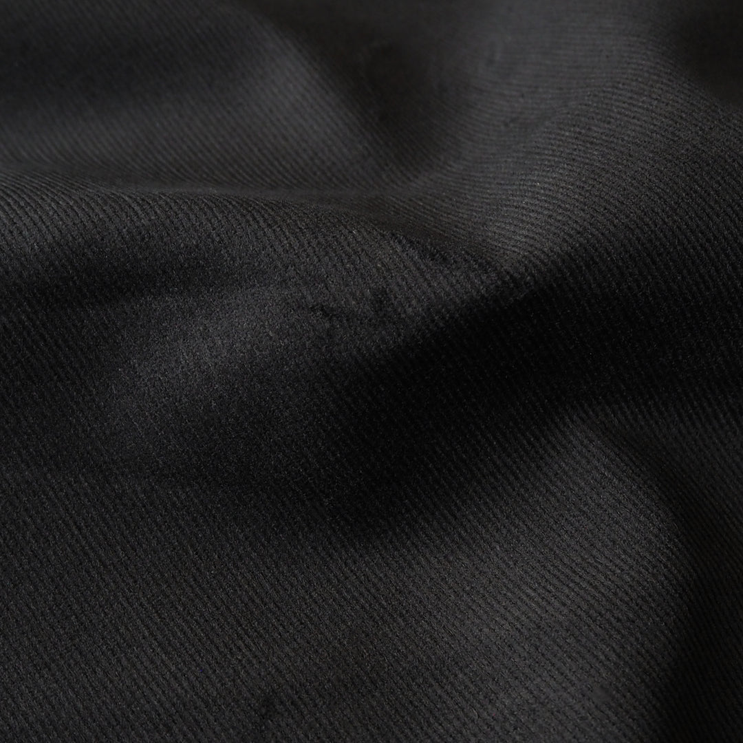 Black stretch cotton needlecord fabric, soft fine cord texture.
