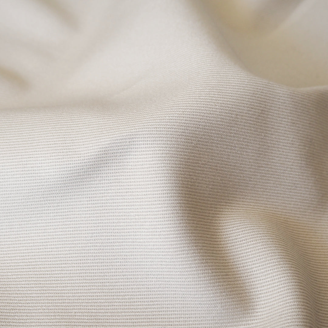 Close up of sevenberry ecru cotton twill fabric, showing the texture of the dressmaking fabric