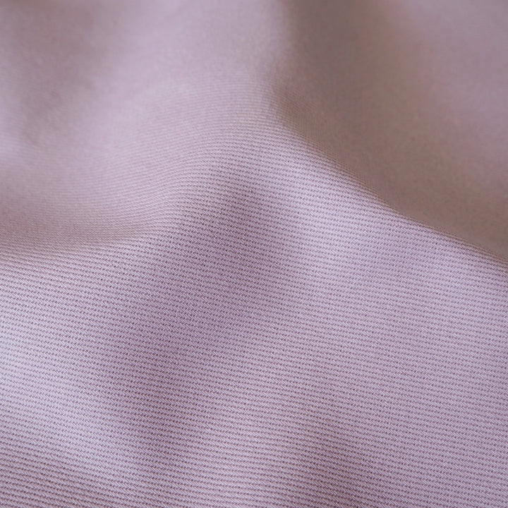Close up of sevenberry lilac purple cotton twill fabric, showing the texture of the dressmaking fabric