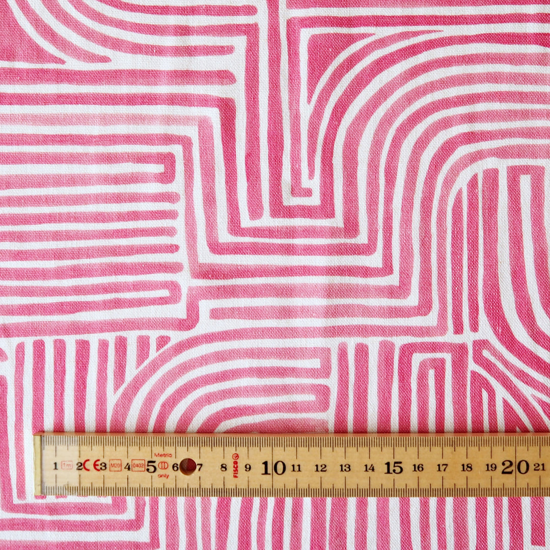Fabric with pink and white wavy line pattern, ruler at the bottom for scale.