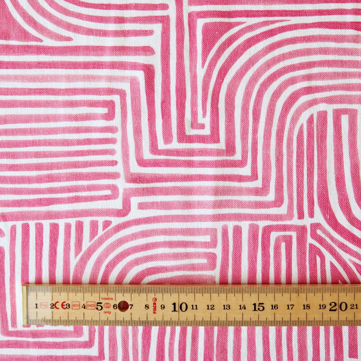 Fabric with pink and white wavy line pattern, ruler at the bottom for scale.