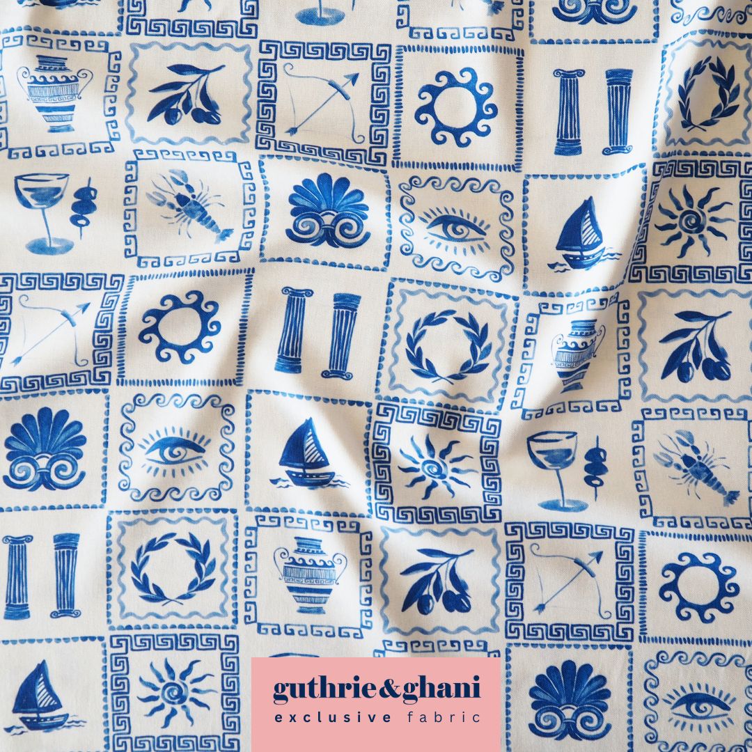 Fabric with blue and white patterns featuring various symbols, displayed by Guthrie & Ghani.