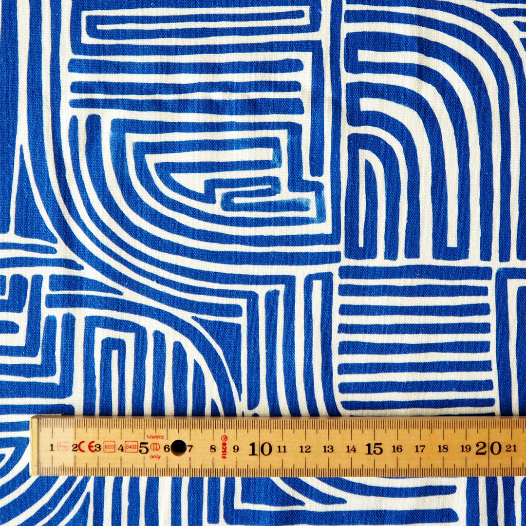 Blue and white geometric patterned fabric with a ruler for scale
