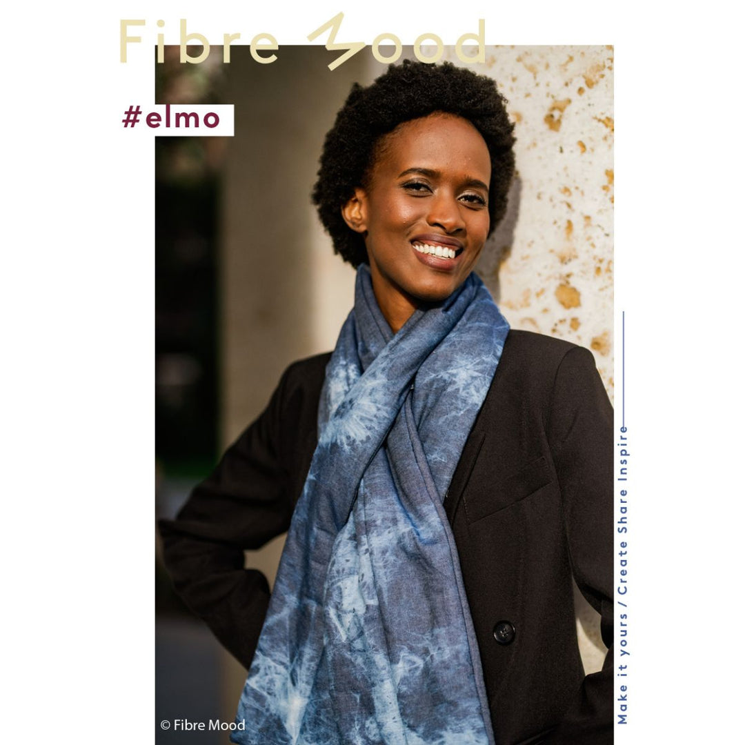 Woman wearing a blue scarf with 'Fibre Mood' branding and '#elmo' text.