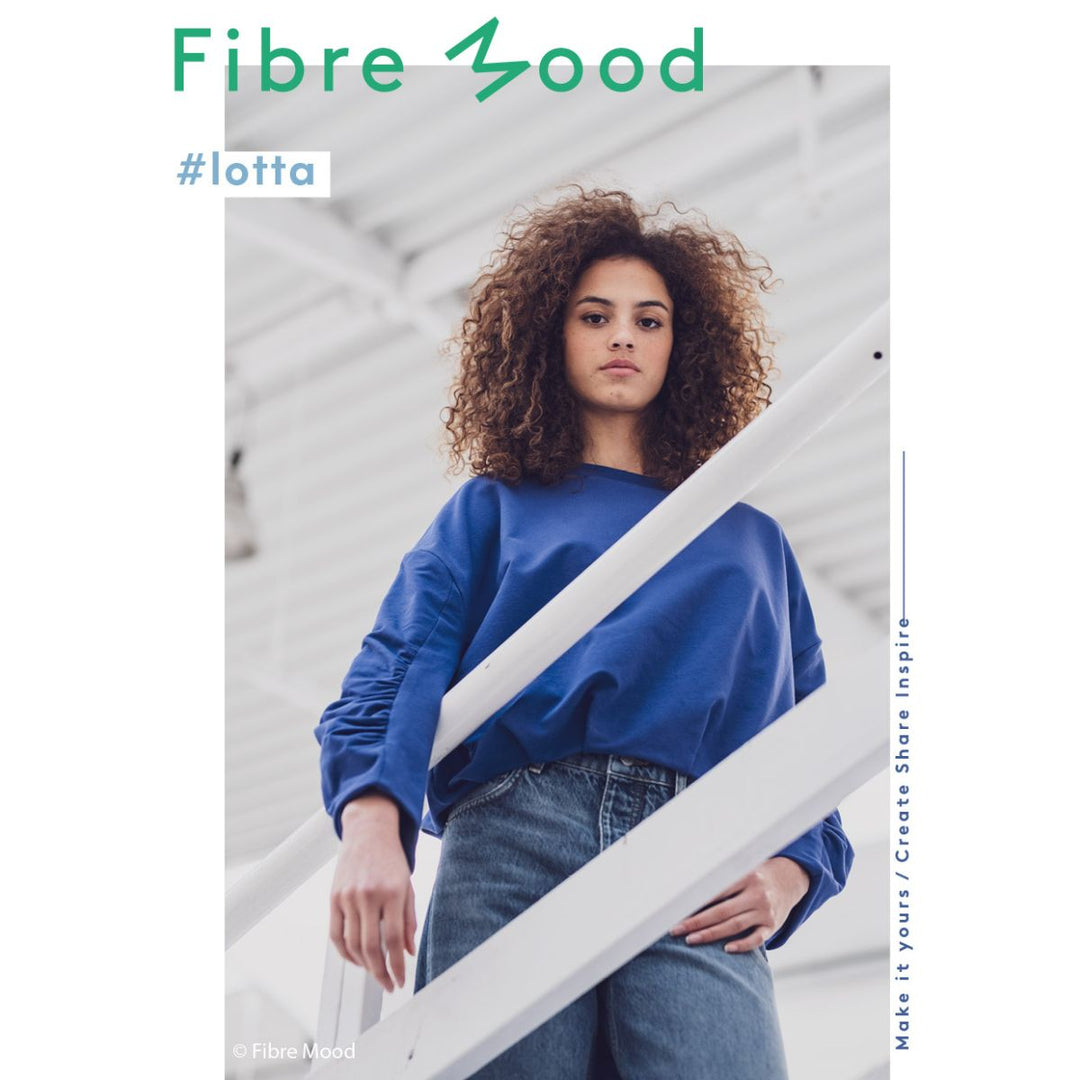 Person wearing a blue sweater and jeans with 'Fibre Mood' branding.