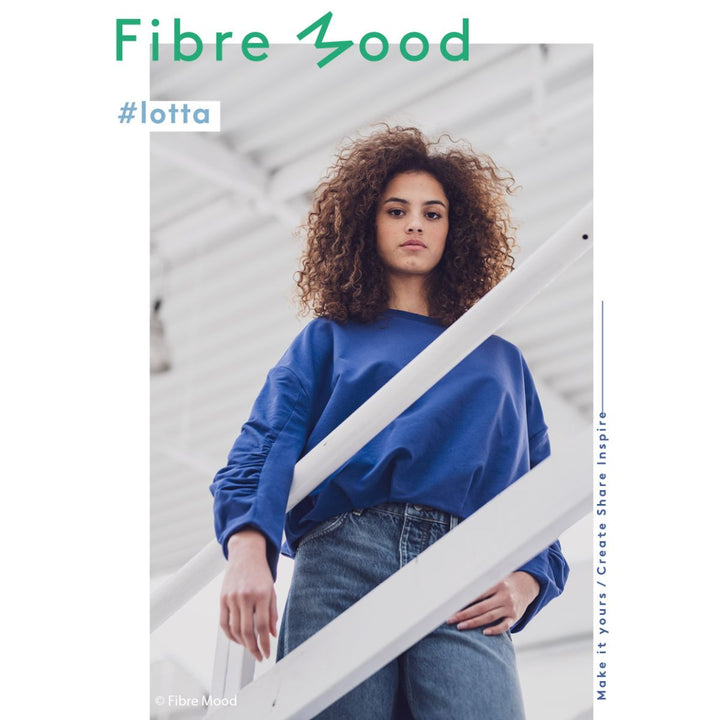 Person wearing a blue sweater and jeans with 'Fibre Mood' branding.