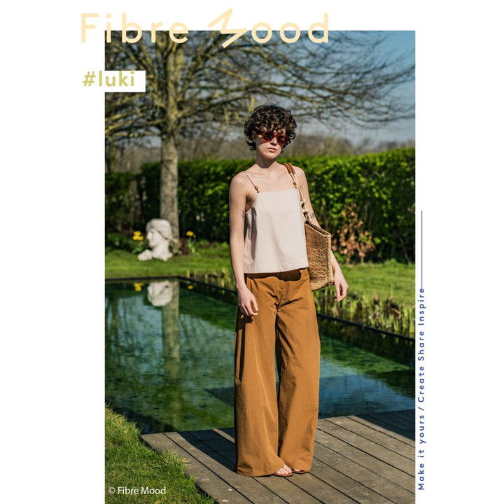 Woman standing by a pond with 'Fibre Mood' branding