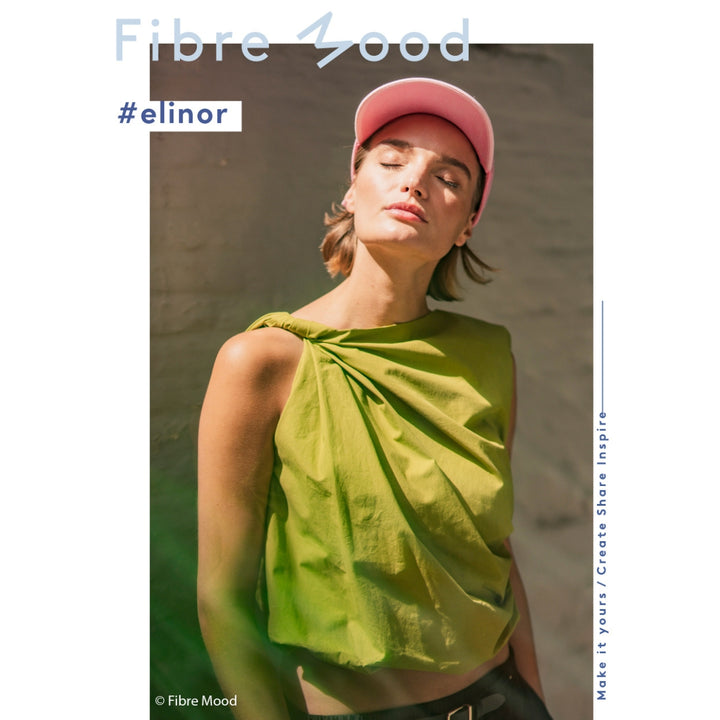 Woman wearing a green top and pink cap with 'Fibre Mood' branding