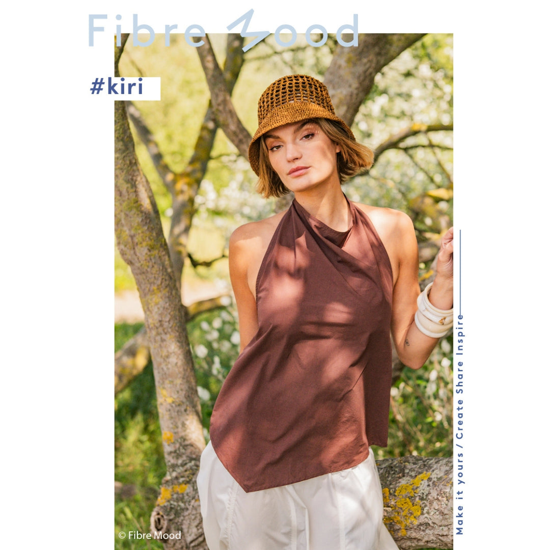Woman wearing a brown halter top and hat outdoors with 'Fibre Mood' branding.