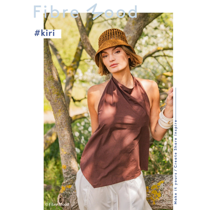 Woman wearing a brown halter top and hat outdoors with 'Fibre Mood' branding.