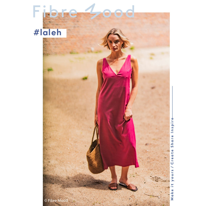 Woman wearing a pink dress standing against a textured wall with 'Fibre Mood' branding.