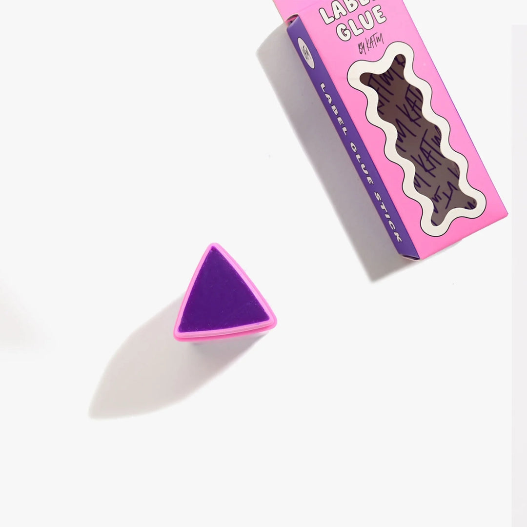 Purple triangle-shaped object with pink border next to a pink and purple packaging on a white background