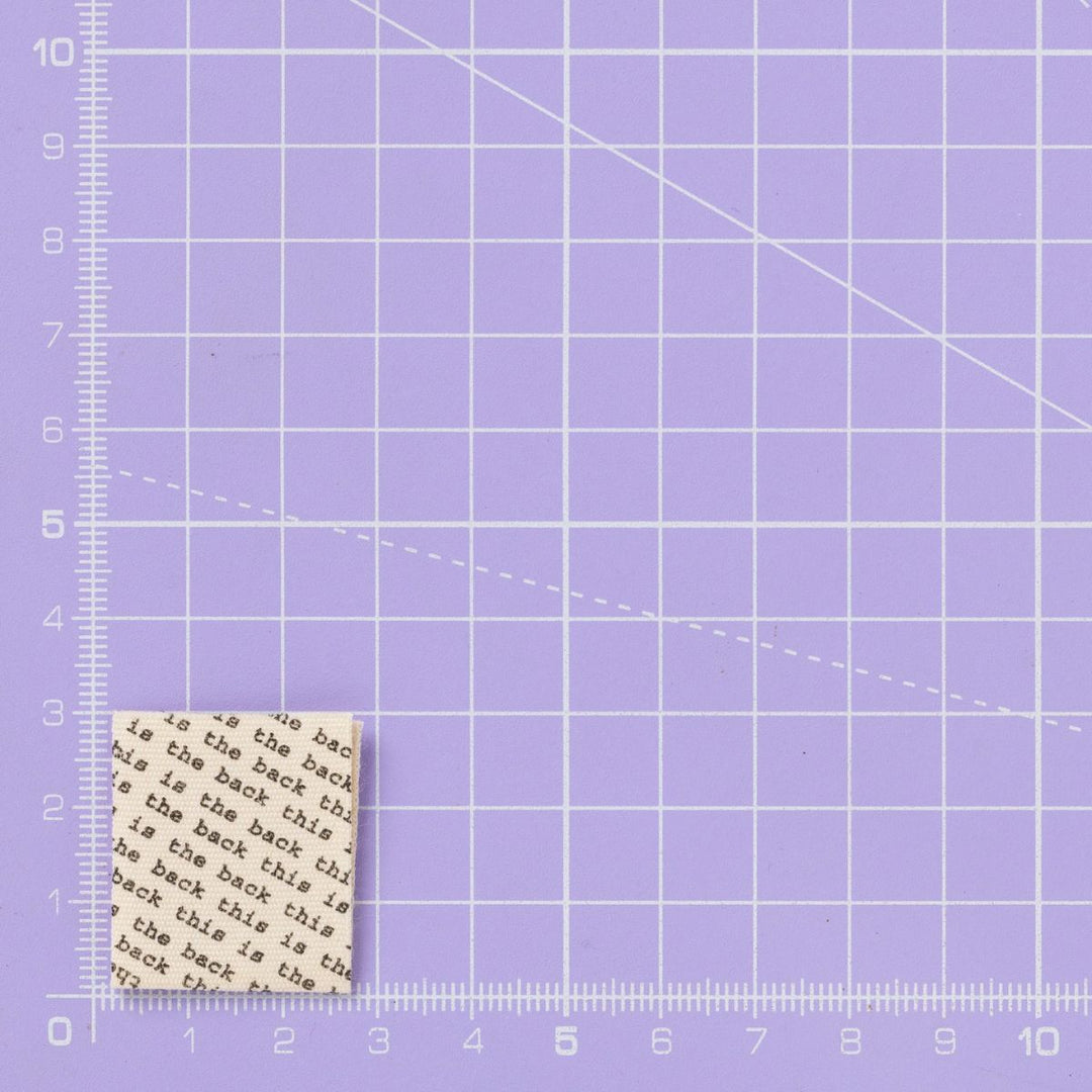 Woven label with text on a purple grid background