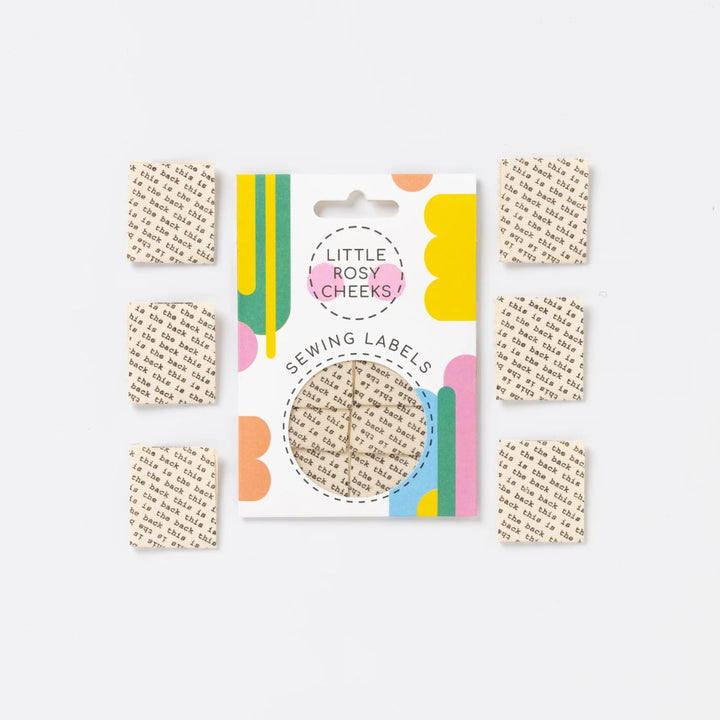 Set of sewing labels with a colorful packaging card labeled 'Little Rosy Cheeks' on a white background.
