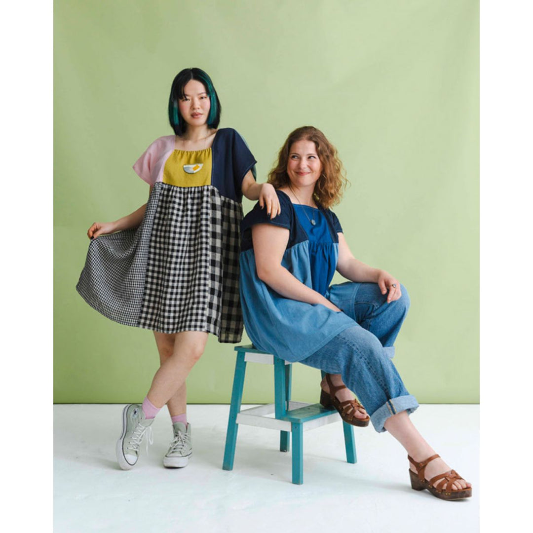 Two women posing together against a green background